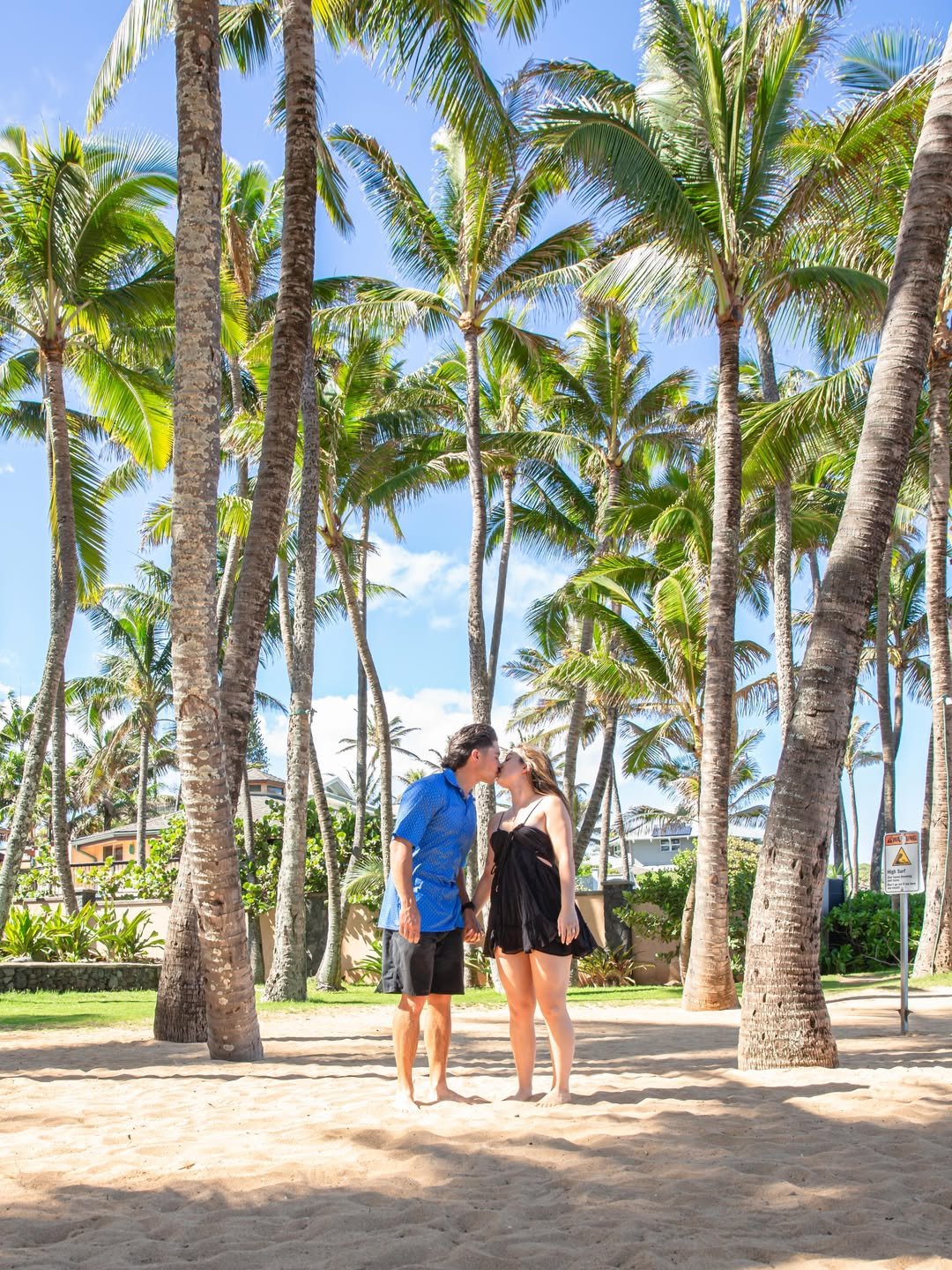 A couple beneath the Maui palms near the shore