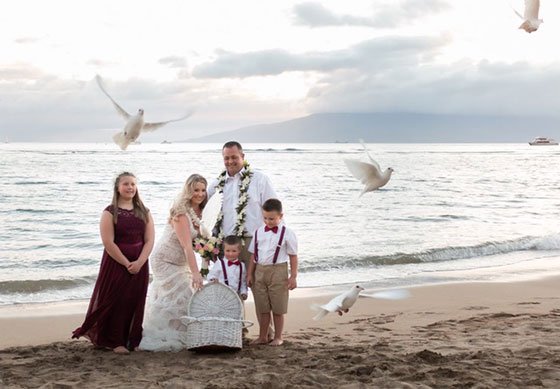 Two photographers covering a Maui beach wedding at golden hour