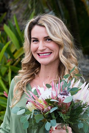 Rachel Schumacher, owner of Maui Beach Weddings and Events, holding a protea bouquet